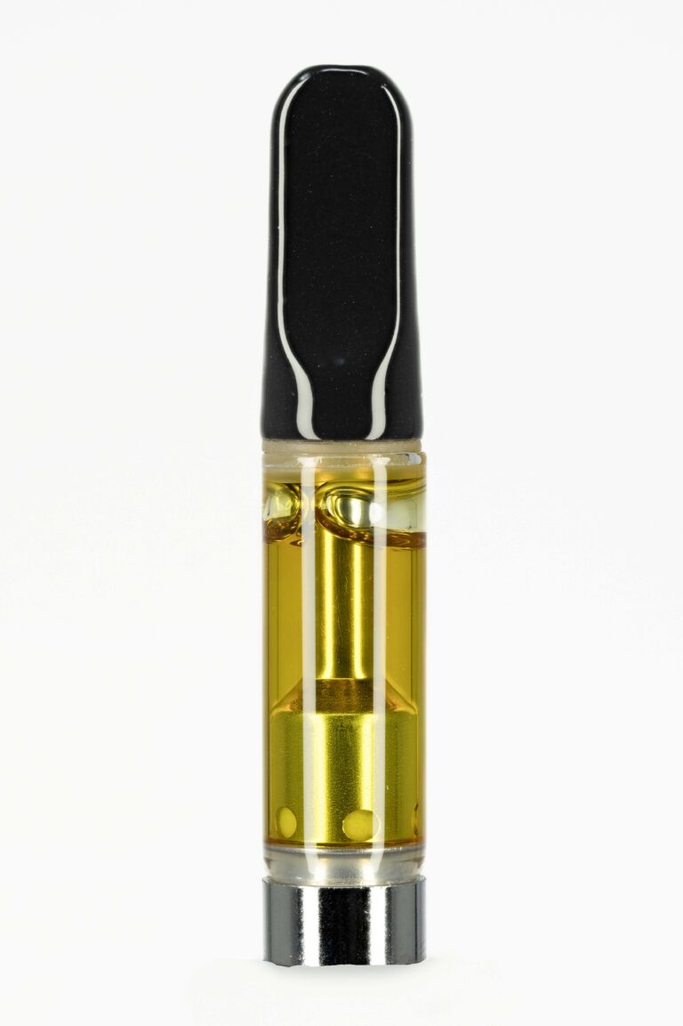 Vape cartridge with golden liquid on white background.