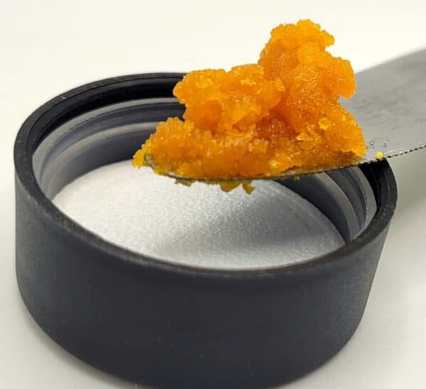 sour bremix wax on a knife over a lid