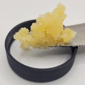 sour magic wax on a knife over a lid