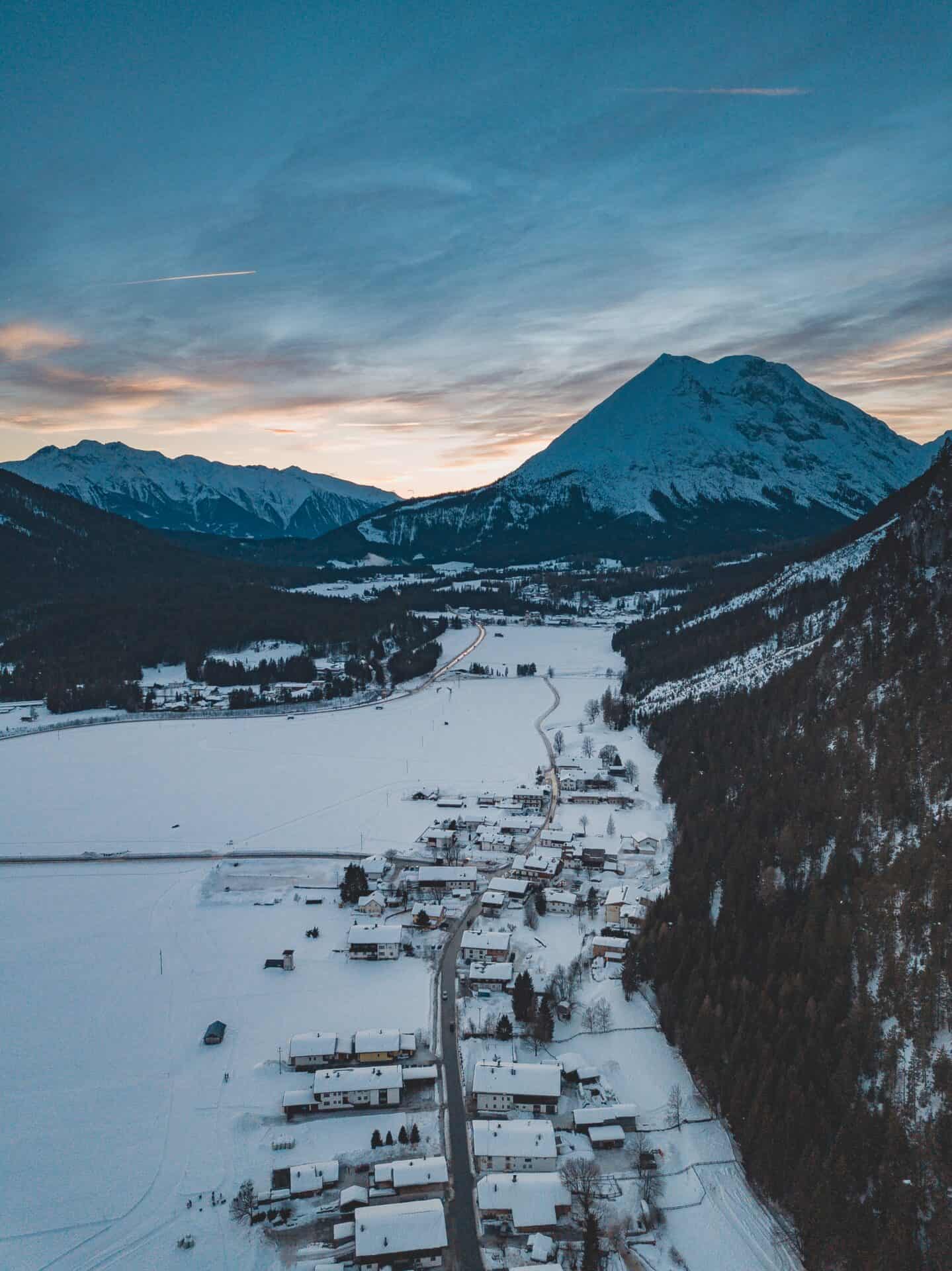 Lab-tested THCa flower shipped to Anchorage Alaska. A breathtaking shot of a mountain range with a town below it in winter